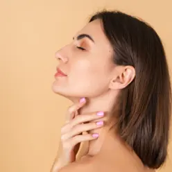 Mulher tocando a região da papada, destacando os cuidados estéticos para reduzir a flacidez e melhorar o contorno facial